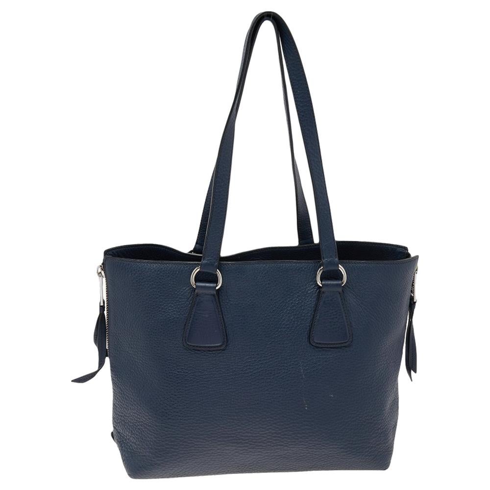 This Prada creation will fetch you admiring glances as this tote is stylish and handy. The bag has been crafted from blue leather and is equipped with dual handles and the logo on the front. The tote comes with a spacious nylon-lined interior.