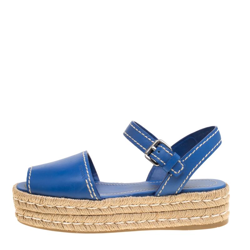 Step out in full style this summer with these pretty espadrilles from Prada. Featuring a blue leather exterior, this trendy peep-toe pair is styled with the contrasting stitch on the uppers as well as on the braided platforms. These are complete
