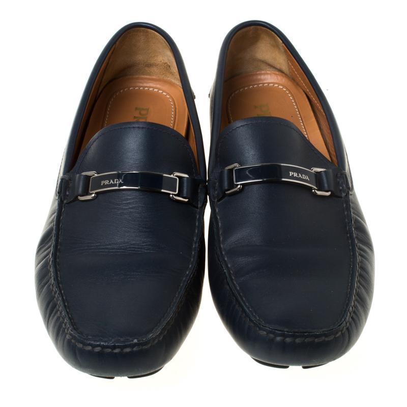 Make a fashion statement wearing these loafers from Prada. These blue loafers are crafted from leather and feature a smart design. They flaunt round toes, a silver-tone logo buckle detailing, comfortable leather lined insoles and rubber