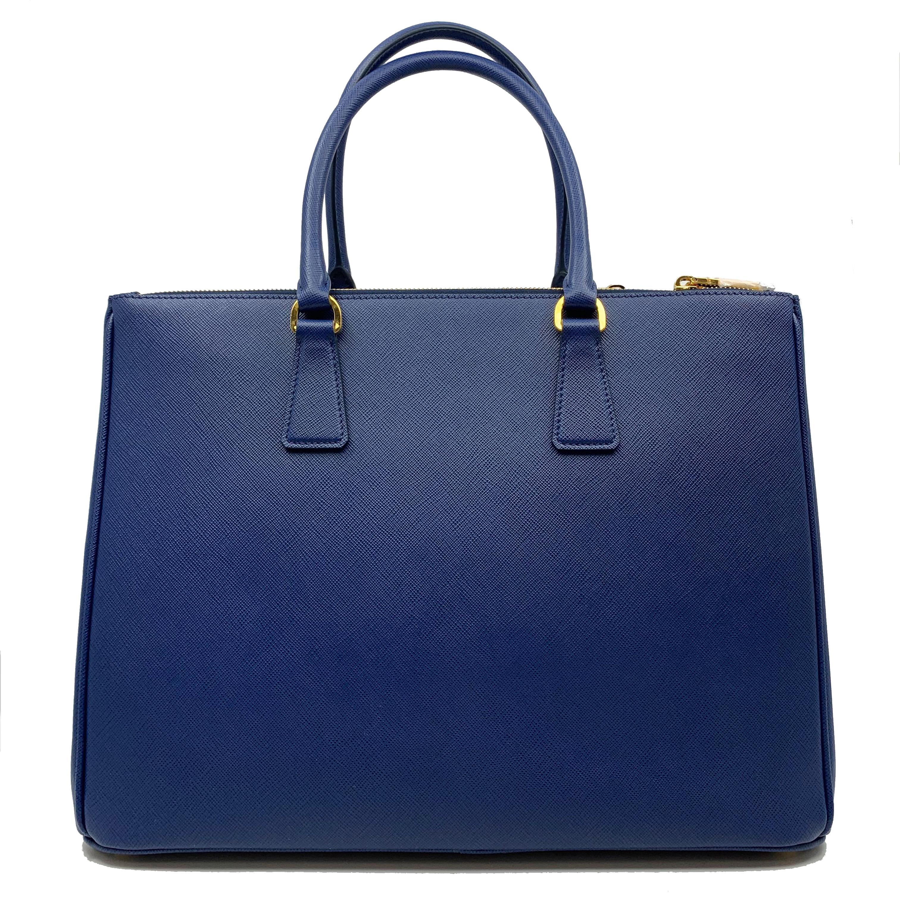 New Without Tags
 Blue Saffiano Calf Leather 
- Double Leather Handle 
- Detachable Key Ring 
- Removable, Adjustable Shoulder Strap 
- Gold-Toned Hardware 
- Triangle Prada Logo with Metal Lettering 
- Expandable Snap Closure on Sides 
- Open Top;