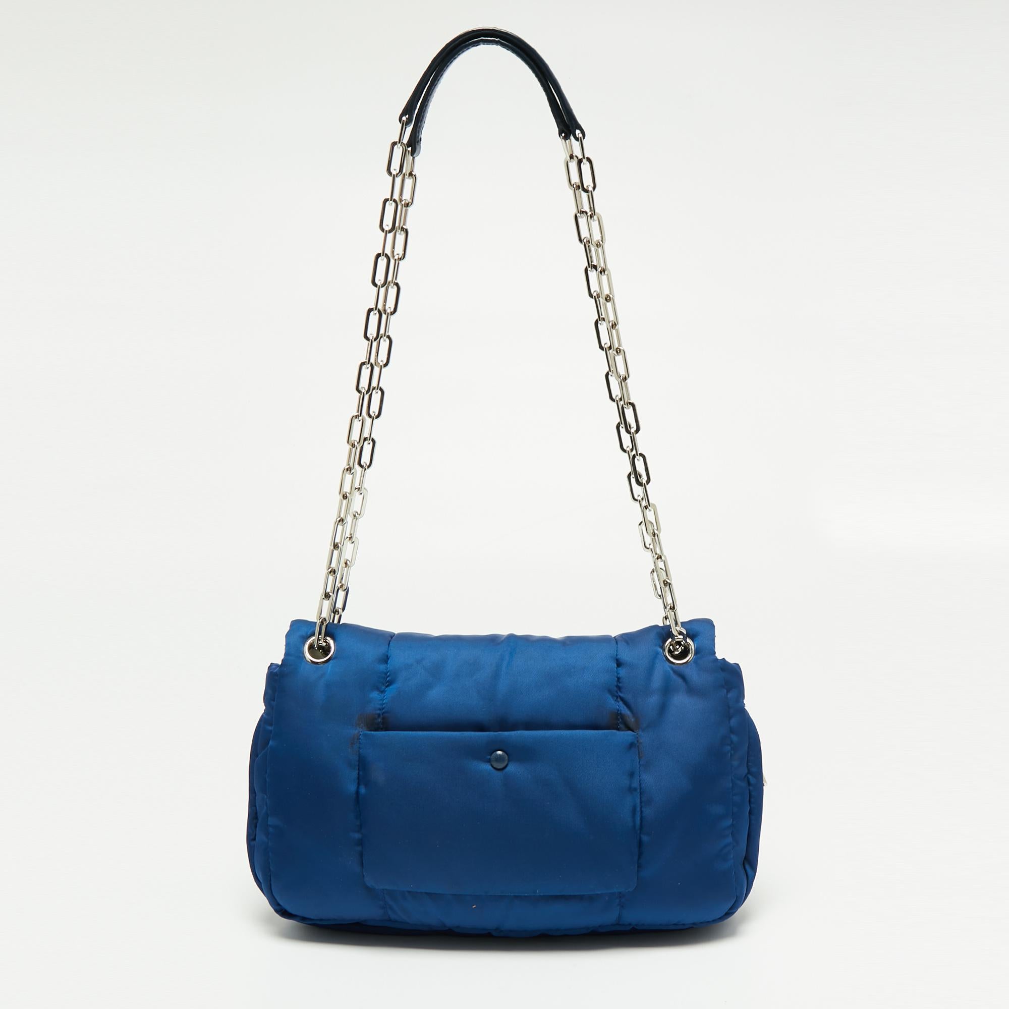 Designed perfectly for your day-to-night endeavors, this chic bag from Prada is worth every penny. Comfortable and easy to carry, this nylon creation comes in a blue shade with a brand-detailed push-lock on the front flap. It features a double