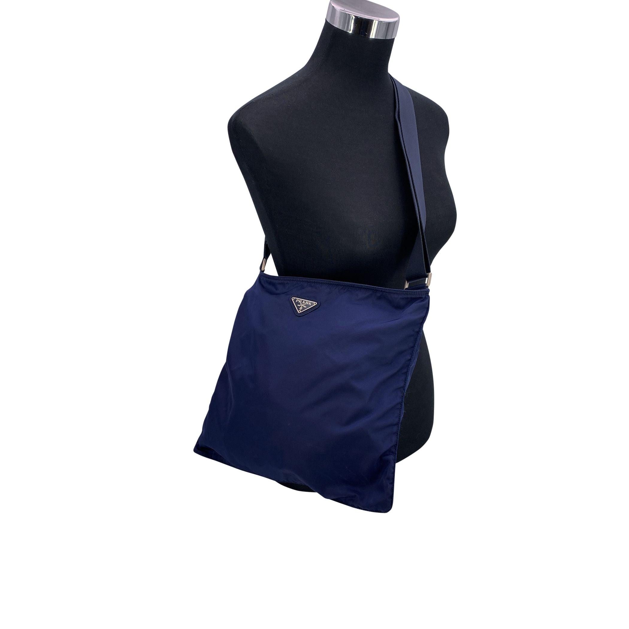 Eleganza e funzionalità si fondono perfettamente con questa borsa messenger di Prada, un pezzo elegante e raffinato che emana una sobria eleganza. Realizzata in resistente tela di nylon blu, questa borsa offre un tocco raffinato e contemporaneo. Il