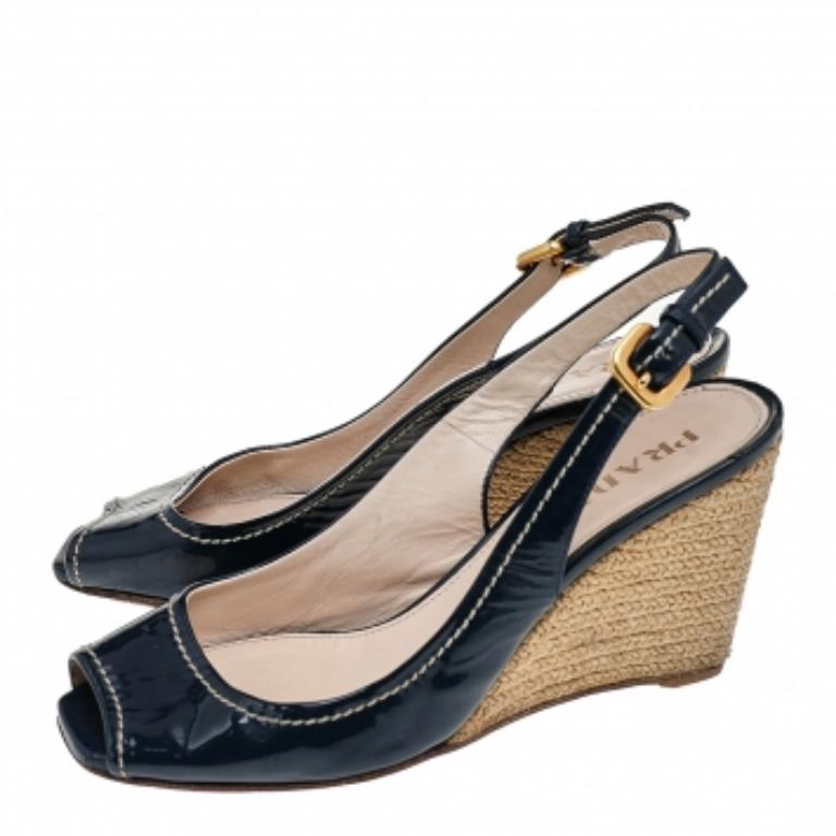 Update your designer collection by adding these sandals from Prada. They are creatively made using navy-blue patent leather on the exterior with gold-toned hardware, contrast stitch detailing, and espadrilles added to their structure. Additionally,