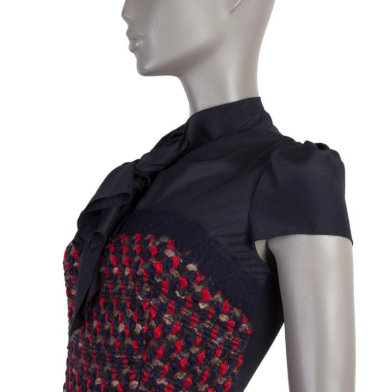 Prada cap-sleeve boucle dress in midnight blue red, and taupe virgin wool (78%), cotton (22%), and silk (100%). With pussy bow on the front, key-hole back, and pleated skirt. Closes with invisible zipper and two buttons on the back. Lined in