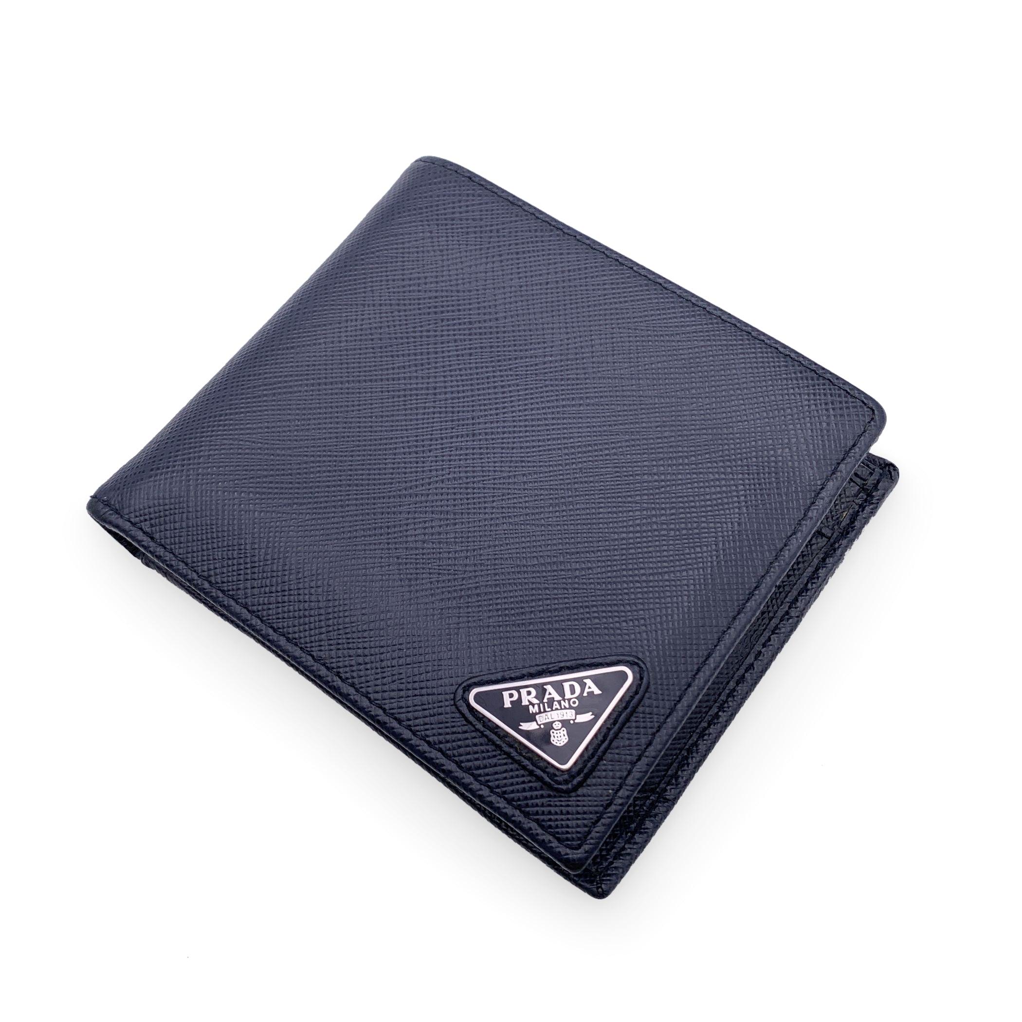 Prada Blue Saffiano leather Bifold Wallet. Bifold design. Prada triangle logo tab on the front. 2 bill compartments, 4 credit card slots and 2 open pockets inside. Leather lining. 'Prada - Made in Italy' engraved inside. Condition B - VERY GOOD