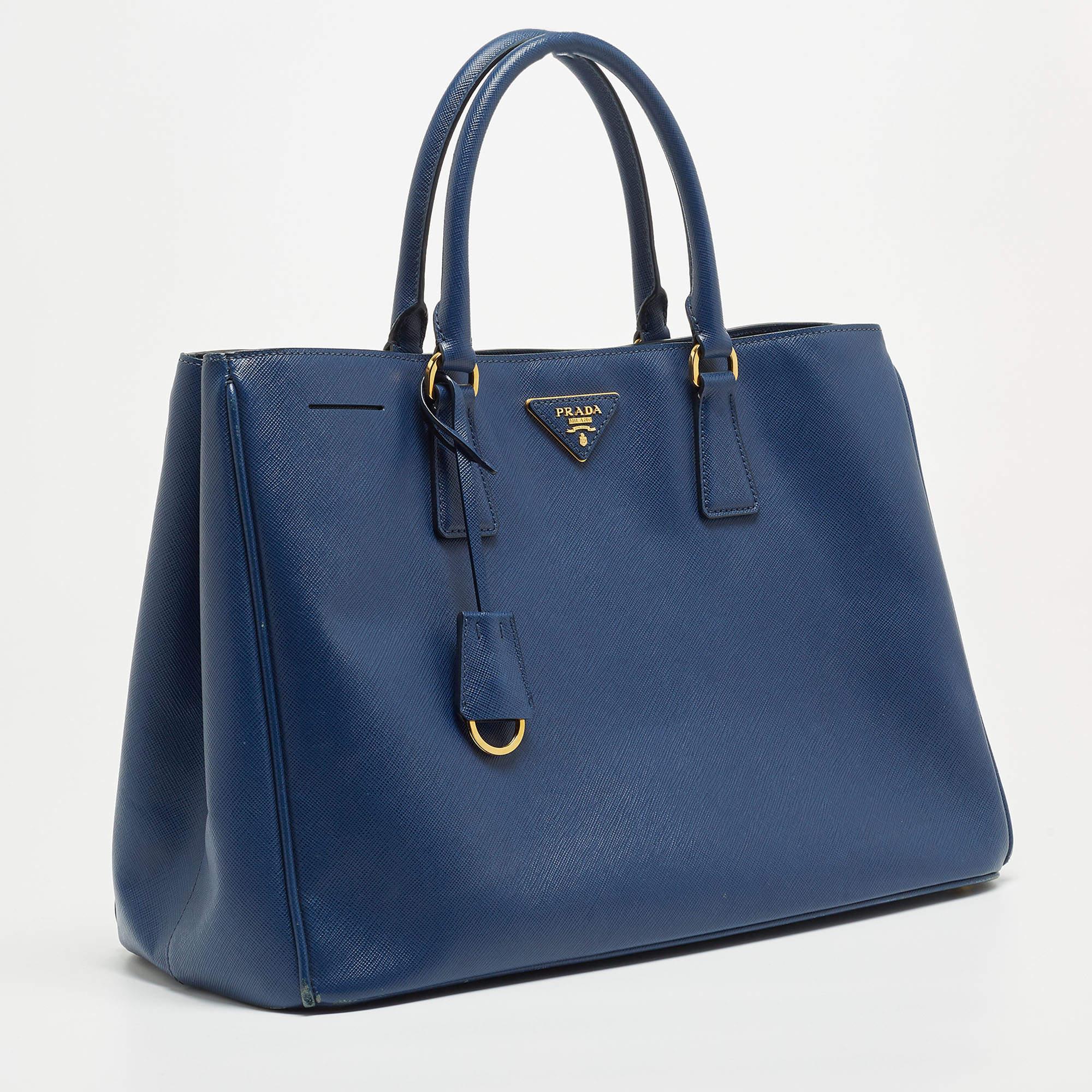 Marked by flawless craftsmanship and enduring appeal, this Prada blue tote is bound to be a versatile and durable accessory. It has a spacious size.

