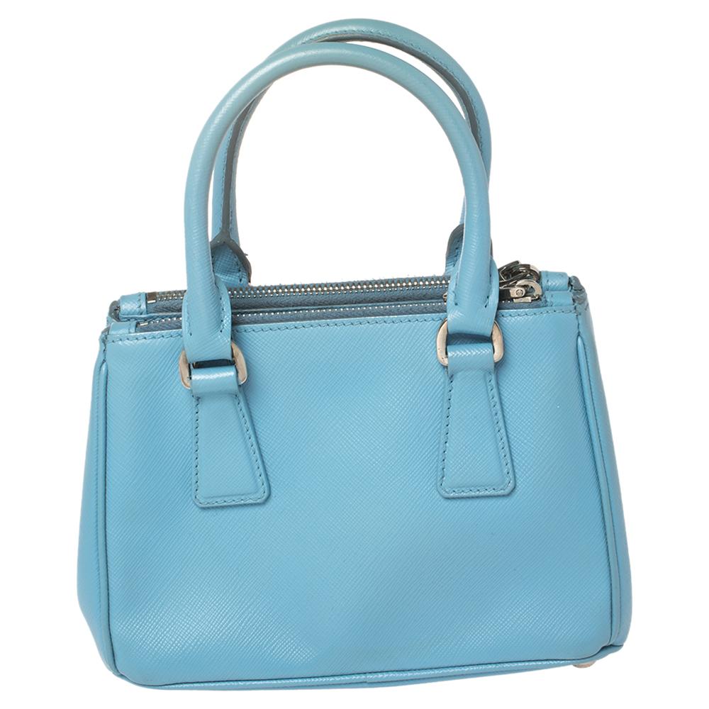 Loved for its classic appeal and functional design, Galleria is one of the most iconic and popular bags from the house of Prada. This beauty in blue is crafted from Saffiano leather and is equipped with two top handles, the brand logo at the front,