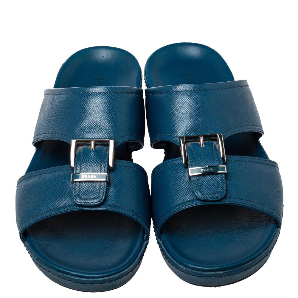 These stylish slides by Prada will make sure your casual dressing is on point. Crafted from leather, they come in a classic shade of blue. They are styled with open toes, buckle detailing on the vamps, silver-tone hardware, and durable rubber