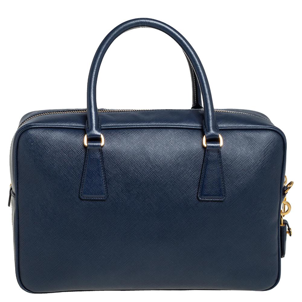 Known for their exclusive craftsmanship, bags from Prada live up to your expectations. This bag comes crafted from Saffiano leather in a blue shade carrying a zip closure, top handles, and a detachable shoulder strap. The interior has a fabric