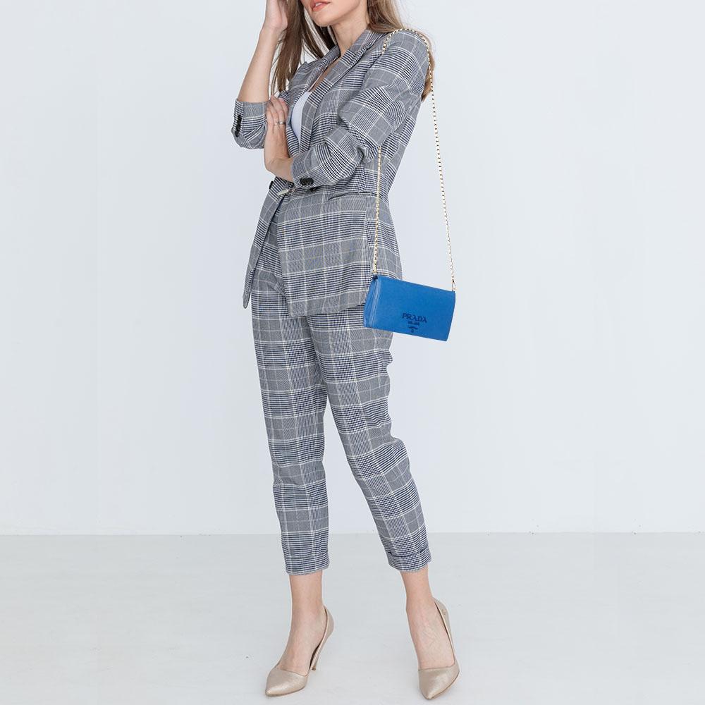 Crafted in Italy, this Prada WOC is made from Saffiano leather and comes in blue. It has a front flap with the signature detail and it opens to a lined interior. The bag is equipped with a shoulder chain in gold-tone.
