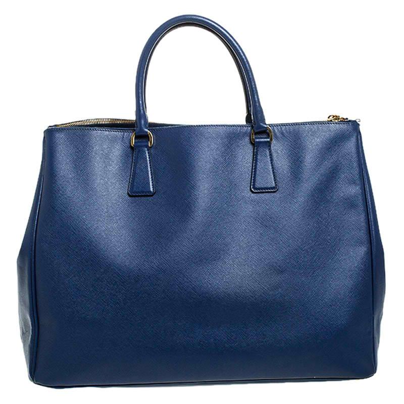 Feminine in shape and grand on design, this Double Zip tote by Prada will be a loved addition to your closet. It has been crafted from leather and styled minimally with gold-tone hardware. It comes with two top handles, two zip compartments and a