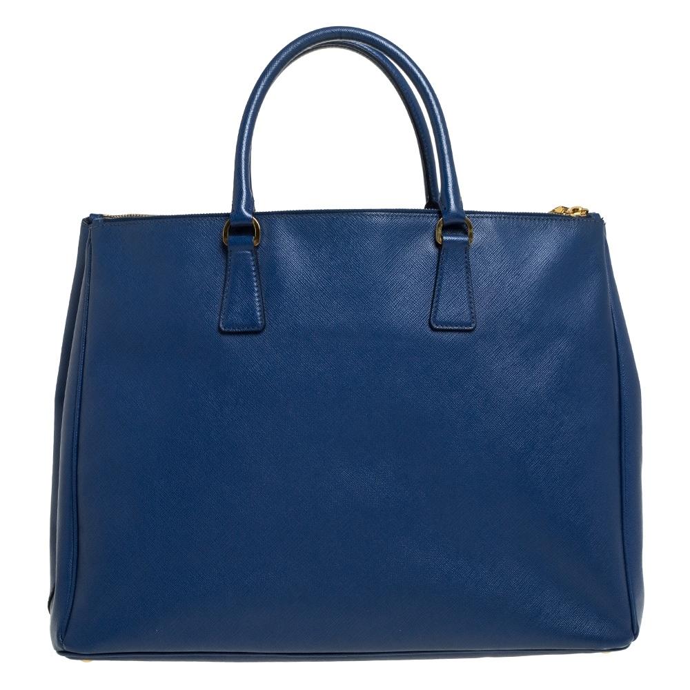 Feminine in shape and grand on design, this Executive Double Zip tote by Prada will be a loved addition to your closet. It has been crafted from leather and styled minimally with gold-tone hardware. It comes with two top handles, two zip