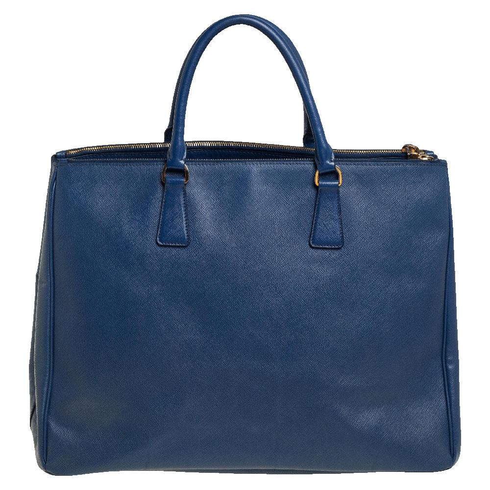 Loved for its classic appeal and functional design, Galleria is one of the most iconic and popular bags from the house of Prada. This beauty in blue is crafted from Saffiano Lux leather and is equipped with two top handles, the brand logo at the