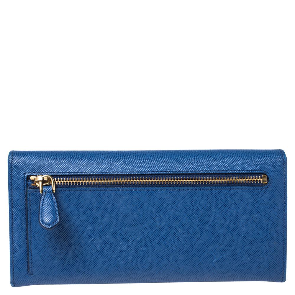 Store your essentials effortlessly in this sturdy continental wallet by Prada. Crafted from Saffiano leather, it comes in a lovely shade of blue. It is styled with a front flap with the brand logo that opens to reveal a leather and nylon interior