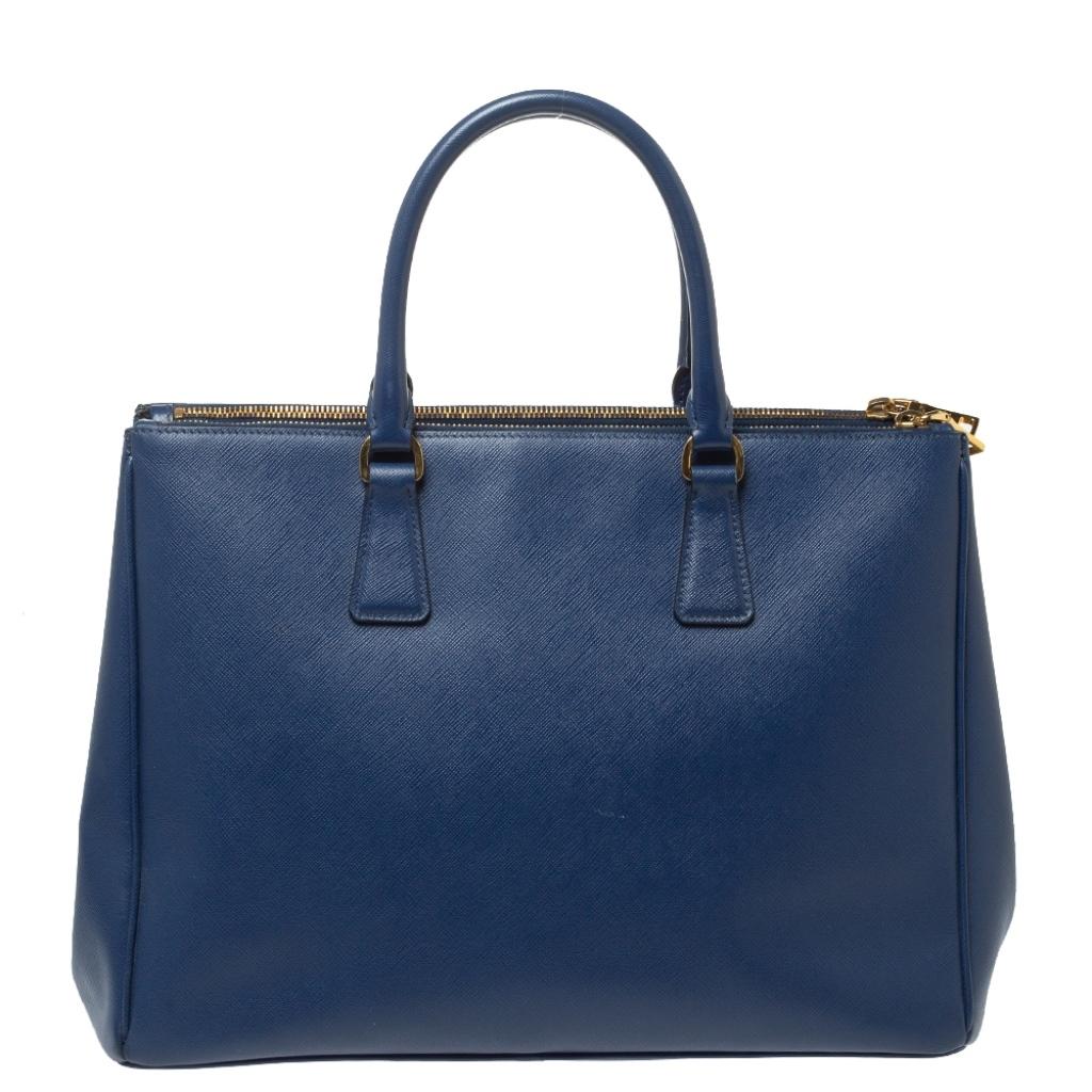 Feminine in shape and grand on design, this Double Zip tote by Prada will be a loved addition to your closet. It has been crafted from leather and styled minimally with gold-tone hardware. It comes with two top handles, two zip compartments and a
