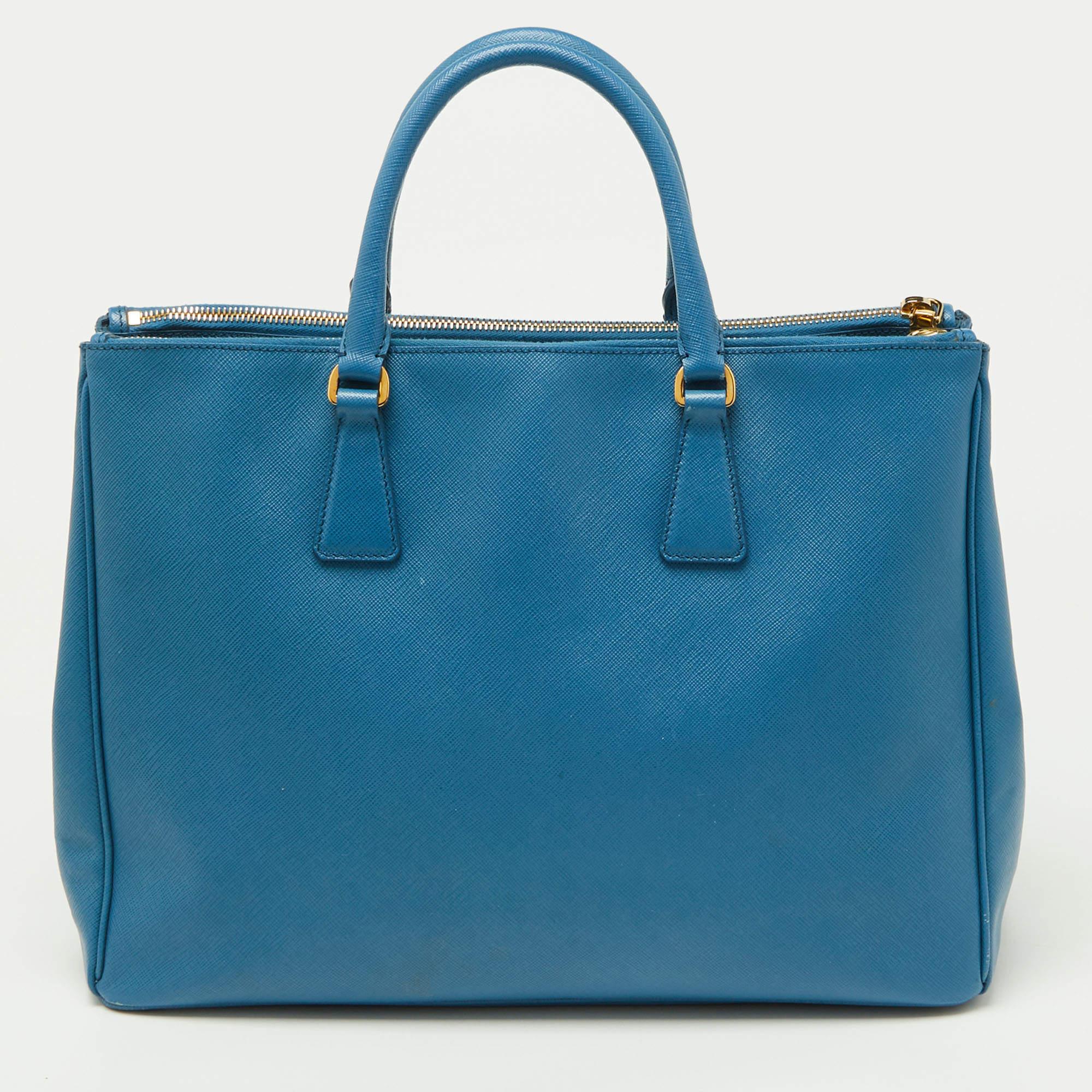 Elevate your style with this Prada blue tote. Merging form and function, this exquisite accessory epitomizes sophistication, ensuring you stand out with elegance and practicality by your side.

