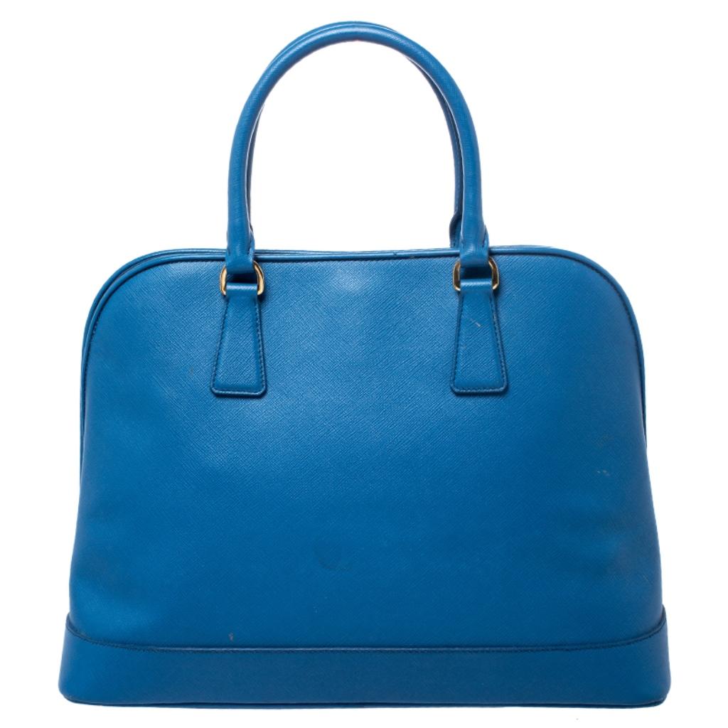 This stunning Promenade tote is high on appeal and style. Dazzling in a classy blue shade, the bag is crafted from Saffiano Lux leather and features two rolled handles. The zip closure leads way to a nylon interior with enough space for your