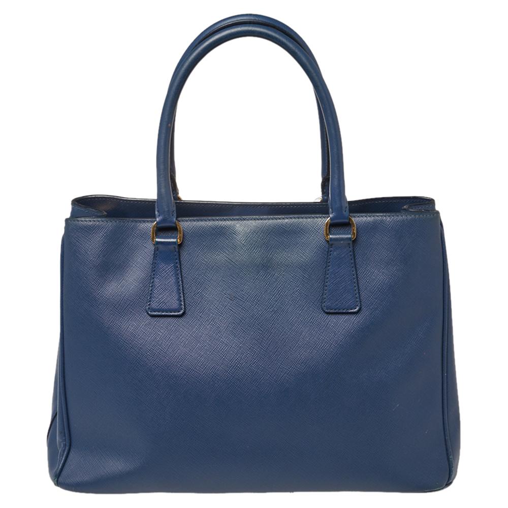 Masterfully crafted using blue Saffiano Lux leather, this bag will make a loved addition. The Prada bag is held by two handles, equipped with metal feet and a nylon interior, and finished with the logo on the front. This is a one-stop fashion