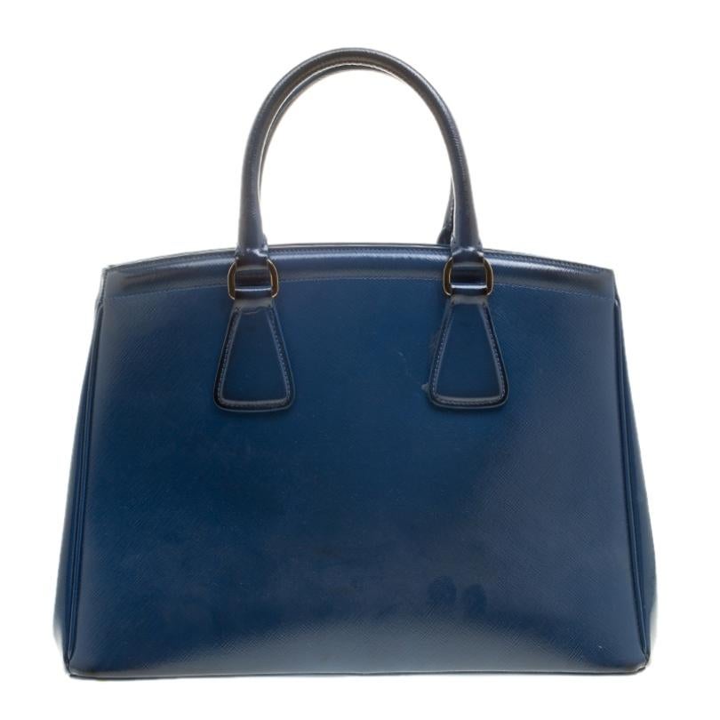 Masterfully created, this Prada tote is a style icon. Designed in a leather body, it exudes style, class and dignity in equal measures. This delightful blue piece is held by two top handles and equipped with a spacious nylon interior.

Includes: The