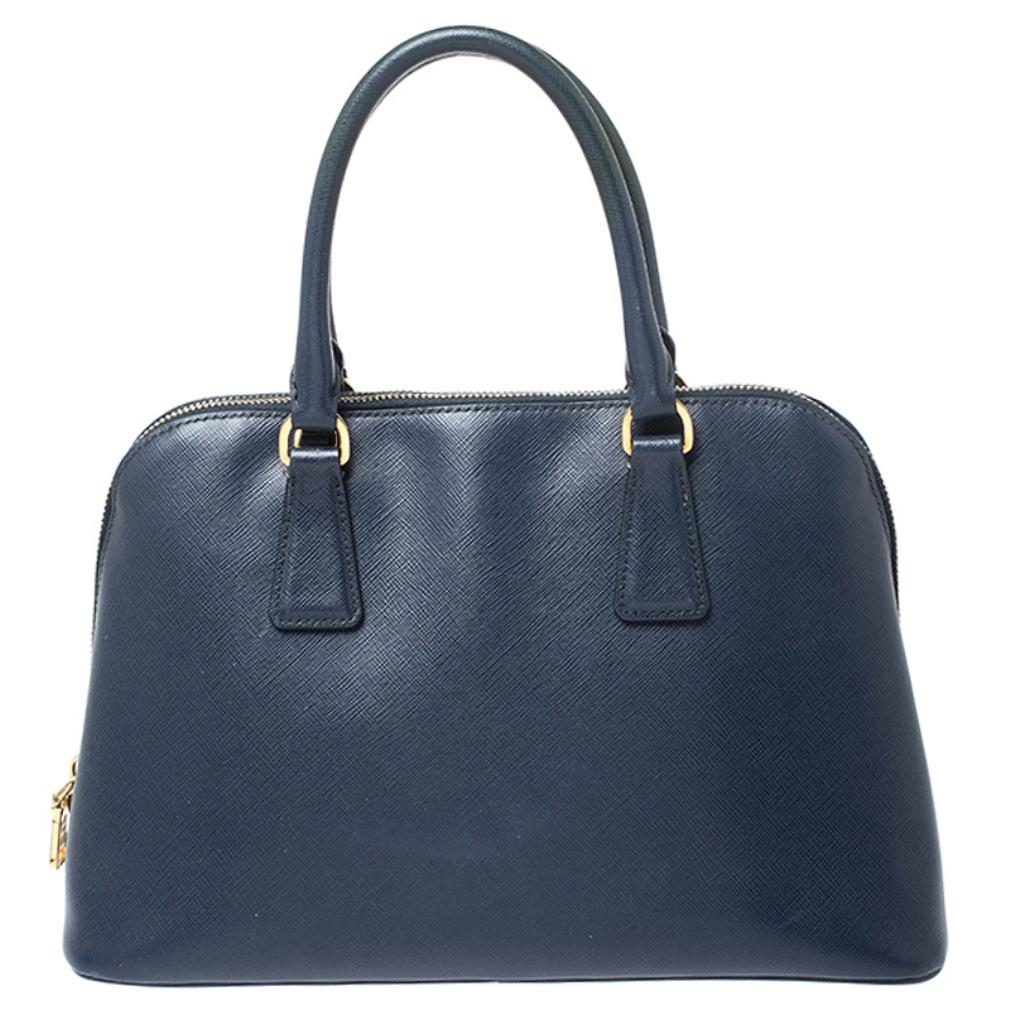 This stunning Promenade bag is high on appeal and style. Dazzling in a classy blue shade, the bag is crafted from leather and features two rolled handles. The zip closure leads way to a nylon interior with enough space for your essentials and the