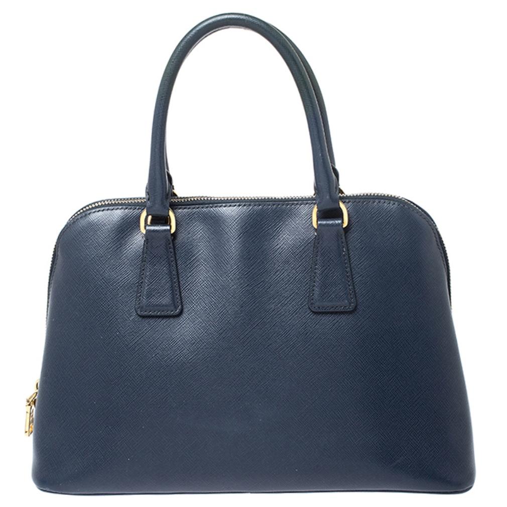 This stunning Promenade bag is high on appeal and style. Dazzling in a classy blue shade, the bag is crafted from leather and features two rolled handles. The zip closure leads way to a nylon interior with enough space for your essentials and the
