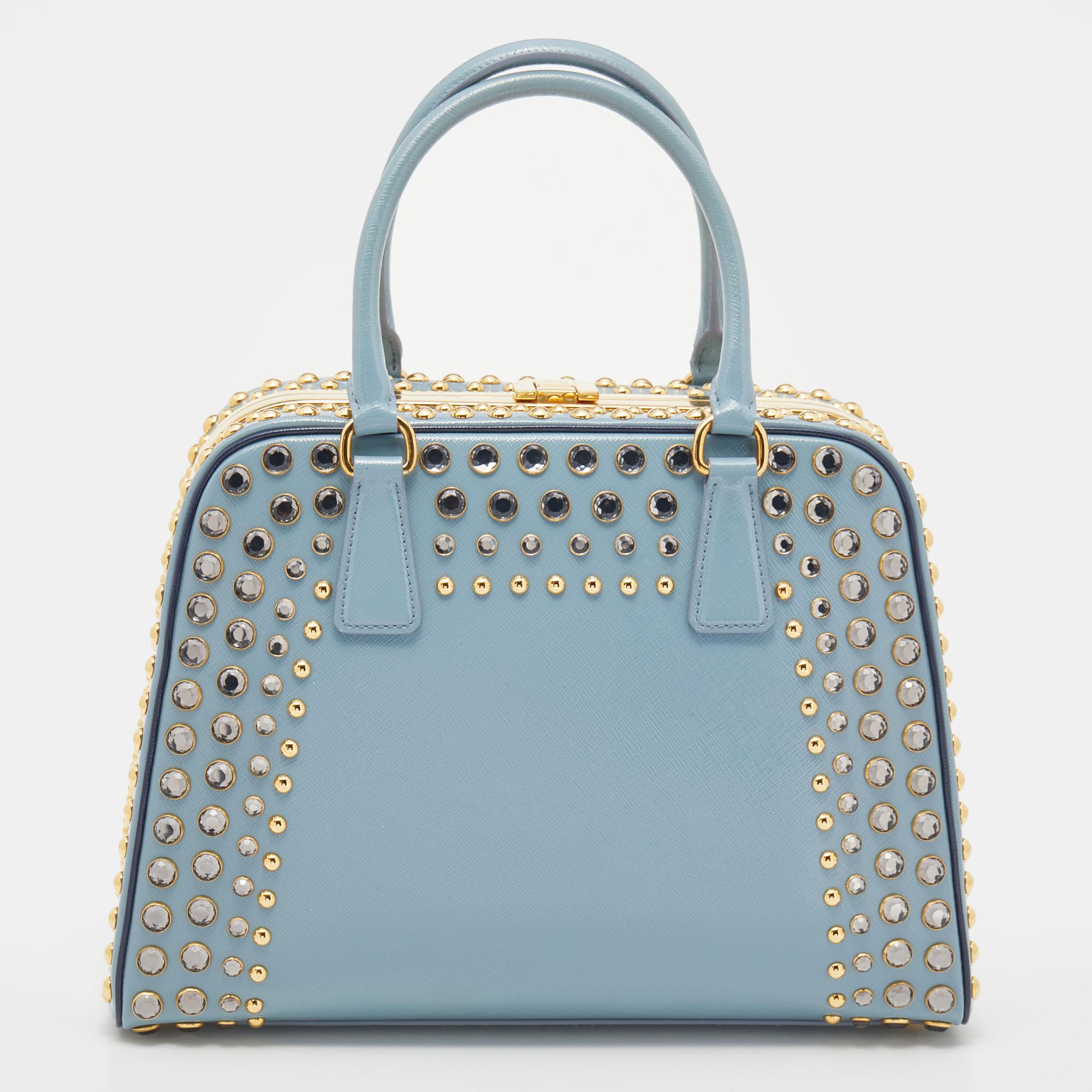 Giving handle bags an elegant update, this Pyramid Frame satchel by Prada aims to be a valuable addition to your closet. It is crafted from Saffiano Vernice leather and styled with crystal embellishments. It comes with dual top handles, protective