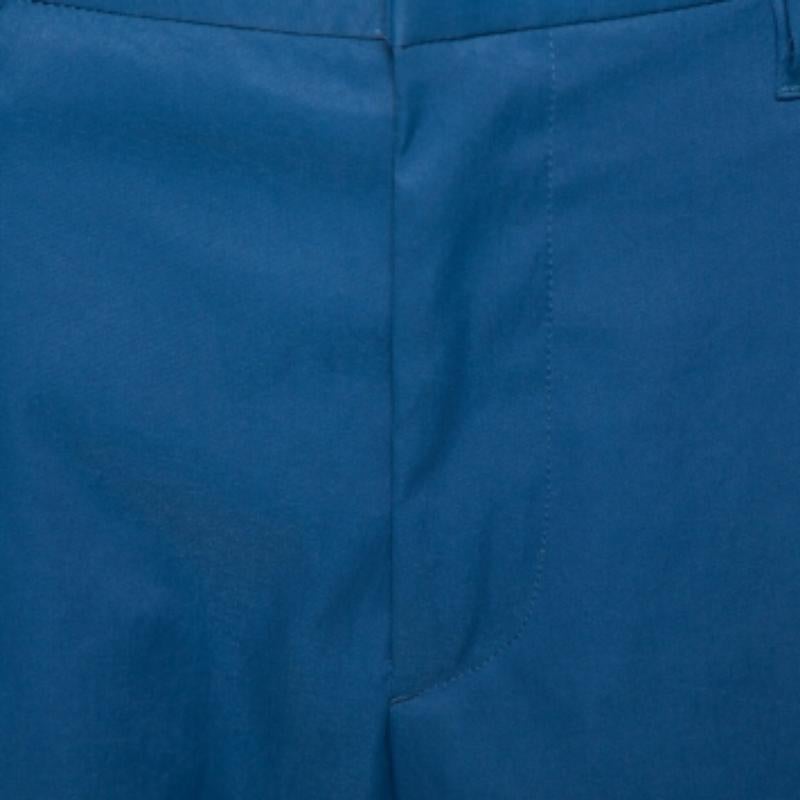 Get comfortable in true Prada style with these blue capri pants for men. Tailored using quality fabrics, the pair features front zip-button closure, belt loops on the waistband, and pockets on the sides as well as at the back.