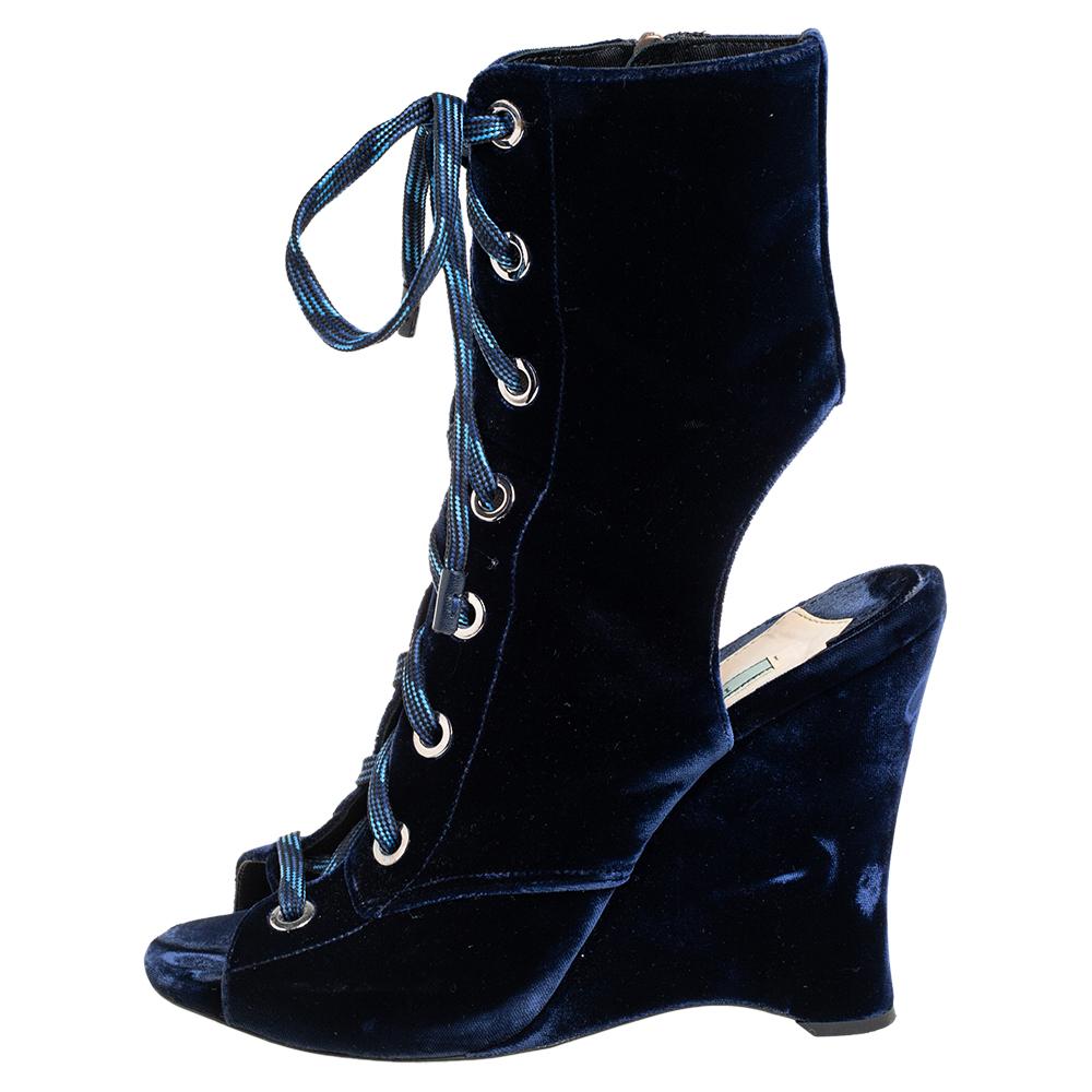 These Prada boots are a reflection of the label's immaculate artistry in shoemaking. Crafted from velvet in a blue shade, they are detailed with laces along the uppers, vamps, and ankles and raised on wedge heels.

Includes: Original Box, Original