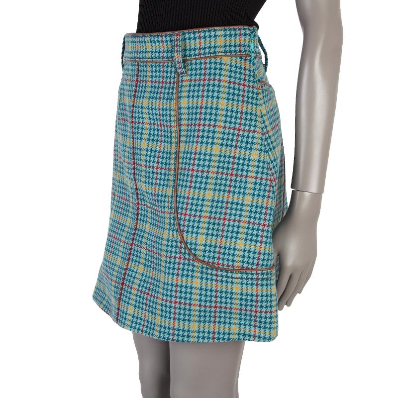 Prada houndstooth a-line skirt in dark and light sea foam, yellow, and red wool (assumed as tag is missing). With belt loops and piping details in cognac leather. Closes with hook and invisible zipper on the side. Lined in dark sea foam fabric. Has