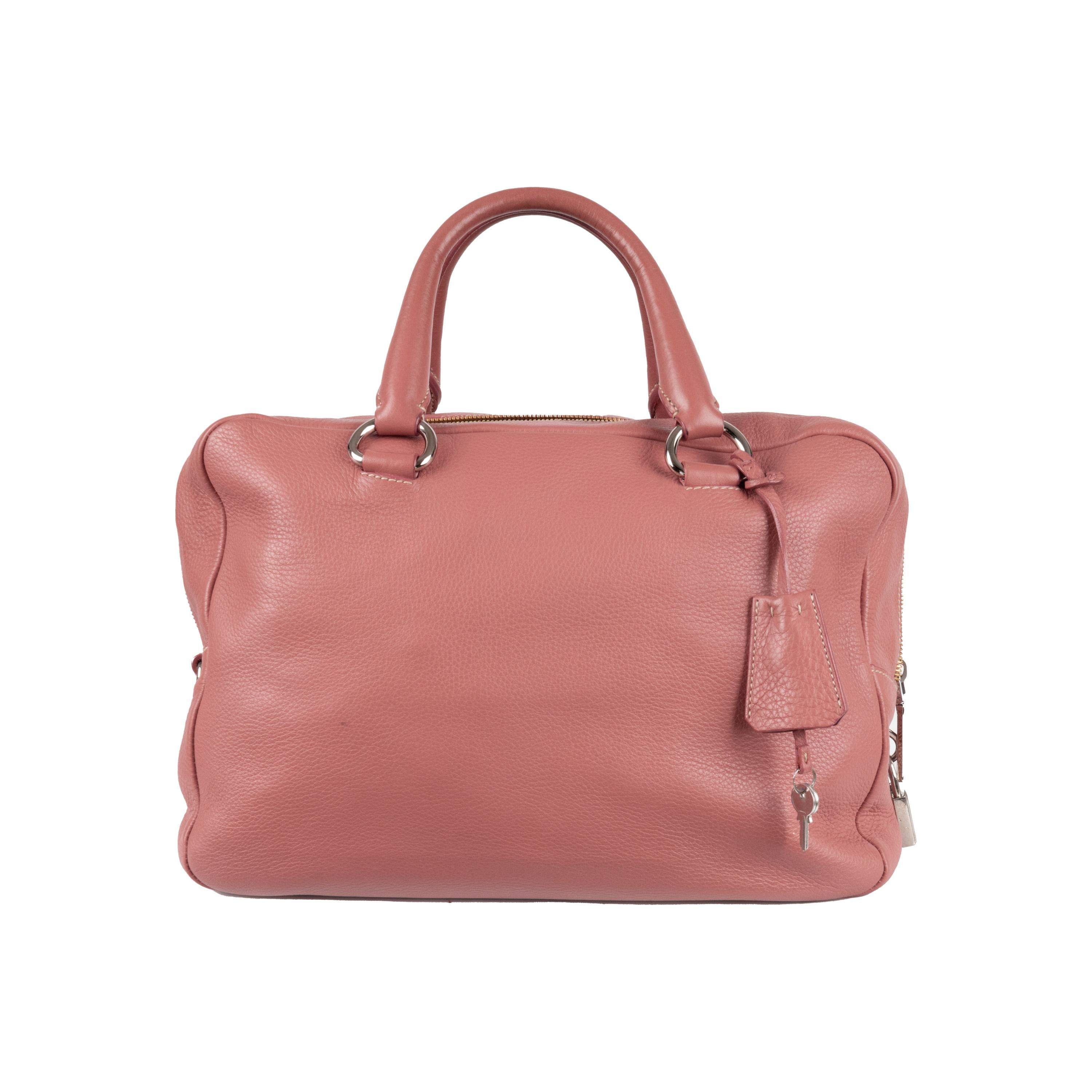 Expertly crafted with soft supple leather in pink, the Prada Boston Handbag is the ultimate everyday accessory. Its ample size comfortably holds all your essentials, while the double zipper detail and silver hardware add a touch of elegance.