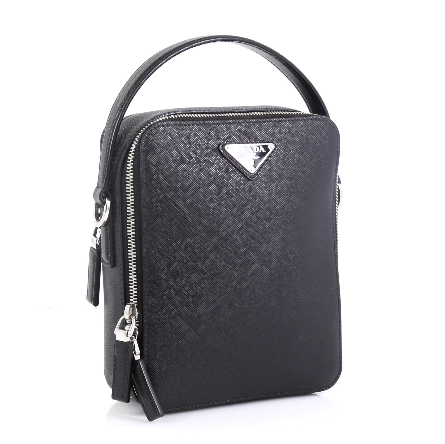 This Prada Brique Crossbody Bag Saffiano Leather Medium, crafted in black leather, features a leather top handle, Prada logo and silver-tone hardware. Its zip closures opens to a black fabric interior with zip pocket. 

Estimated Retail Price: