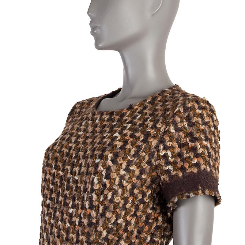 Prada short-sleeve dress in brown, beige, hunter green and orange boucle wool (78%) and cotton (22%) with burgundy felt detail around the waist and sleeves and one box pleat on the front side. Opens with zipper on the back. Lined in brown silk (89%)