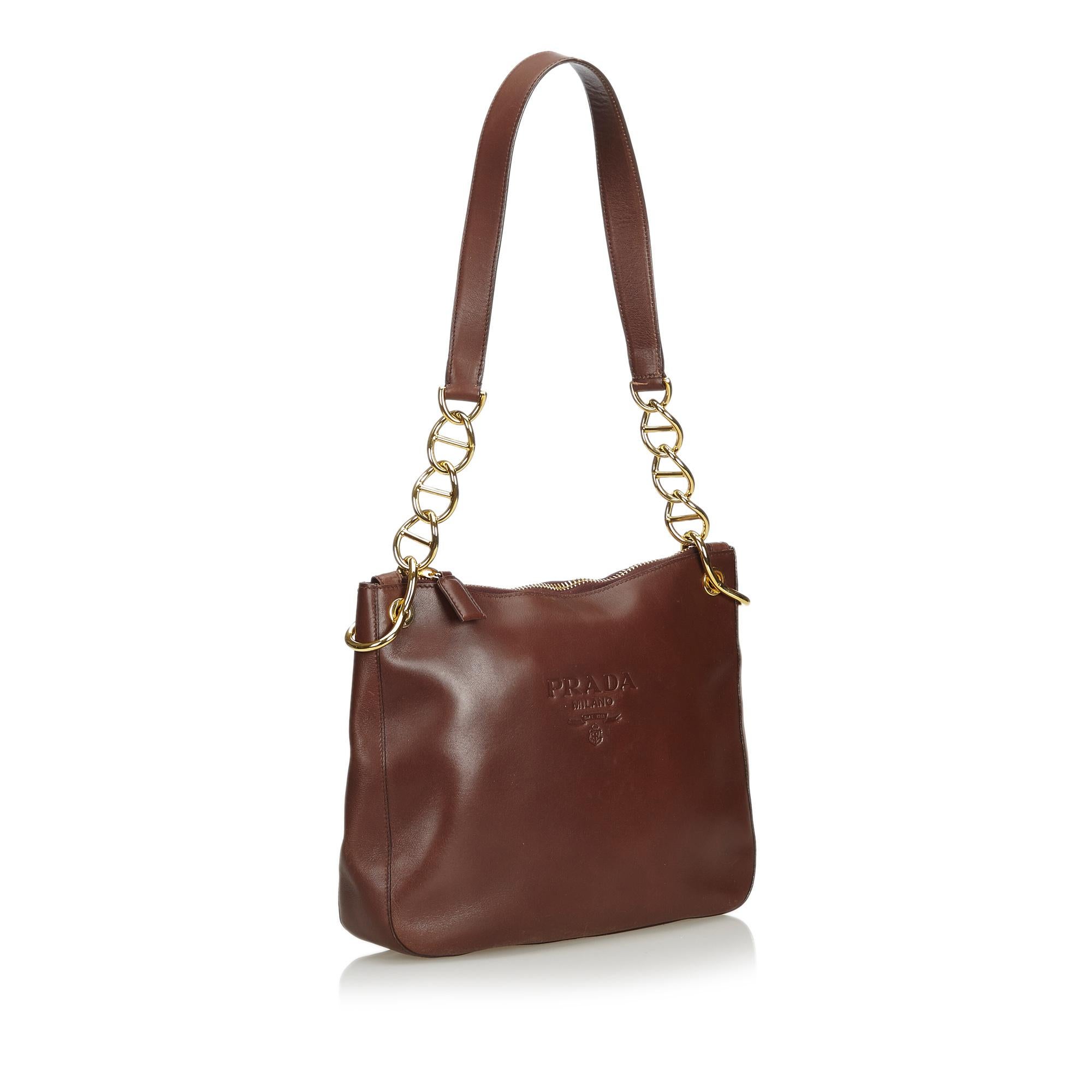 This shoulder bag features a calf leather body, flat leather straps with gold tone chain, a top zip closure, and an interior zip pocket. It carries as B condition rating.

Inclusions: 
Dust Bag

Dimensions:
Length: 23.00 cm
Width: 29.00 cm
Depth: