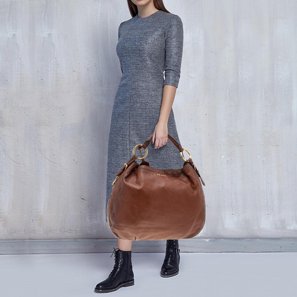 This wonderful bag from Prada is all that you need to instantly uplift your look. The soft and refreshing brown shade blends perfectly with any dress of your choice while the leather makes ensures that you can flaunt a great appearance that is