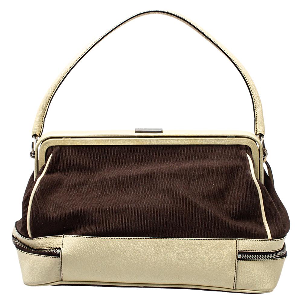 This stylish Doctor bag hails from the house of Prada. It has been crafted from quality canvas & leather and comes in lovely hues of brown & cream. It has double zipper detailing, a top handle and a nylon-lined interior. It is finished with