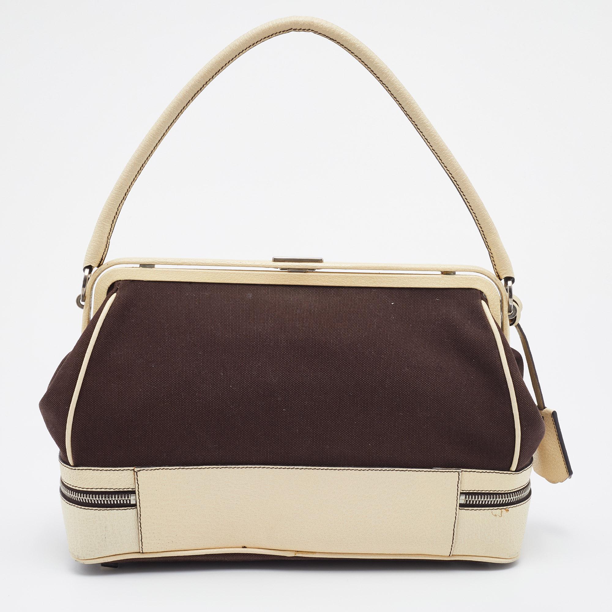 Giving handle bags an elegant update, this Doctor's bag by Prada will be a valuable addition to your closet. It has been crafted from the canvas as well as leather and styled with a zippered base. It comes with a top handle and a perfectly sized