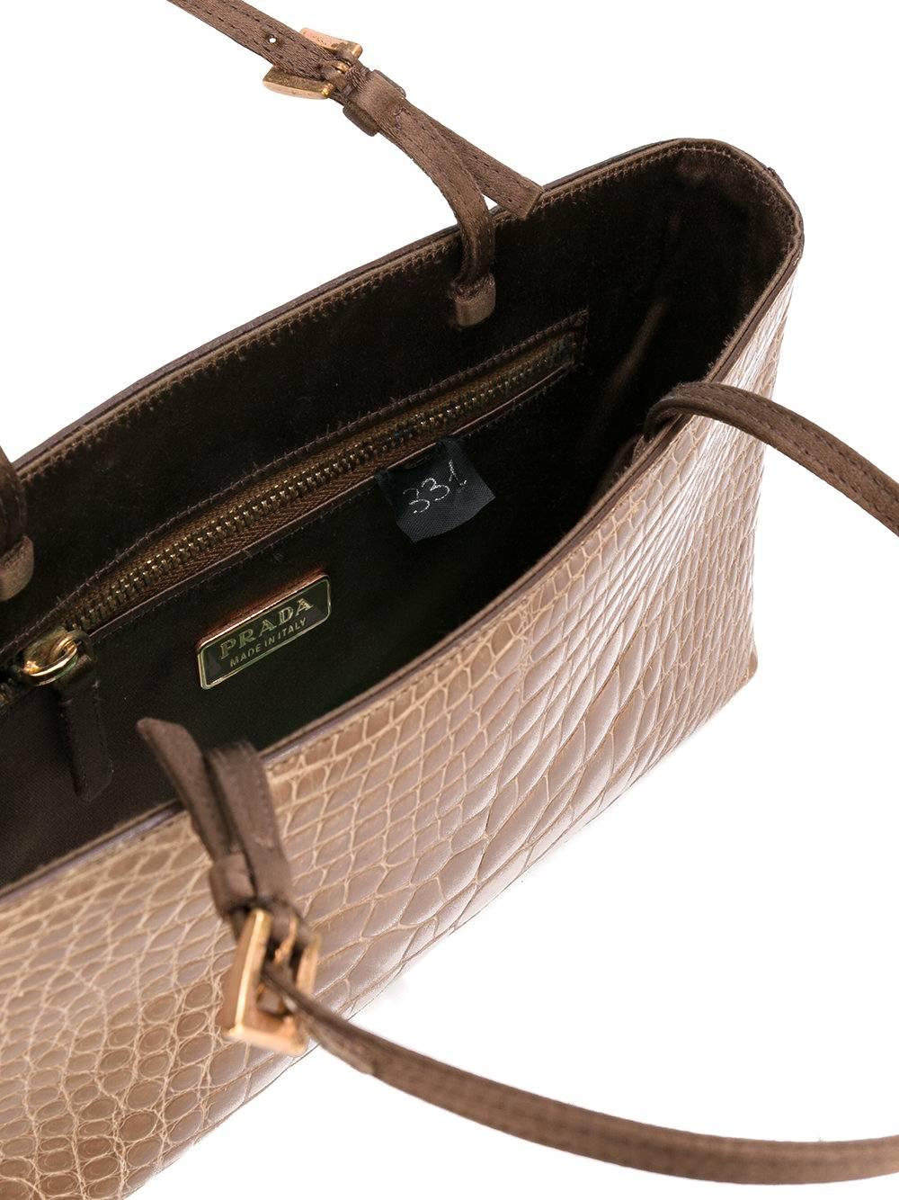Nice Prada light brown crocodile leather small handbag. It features a round top handles, a gold-tone logo plaque and an internal slip pocket. The item is vintage, it was produce in the 2000s and is in excellent conditions, it only shows very light