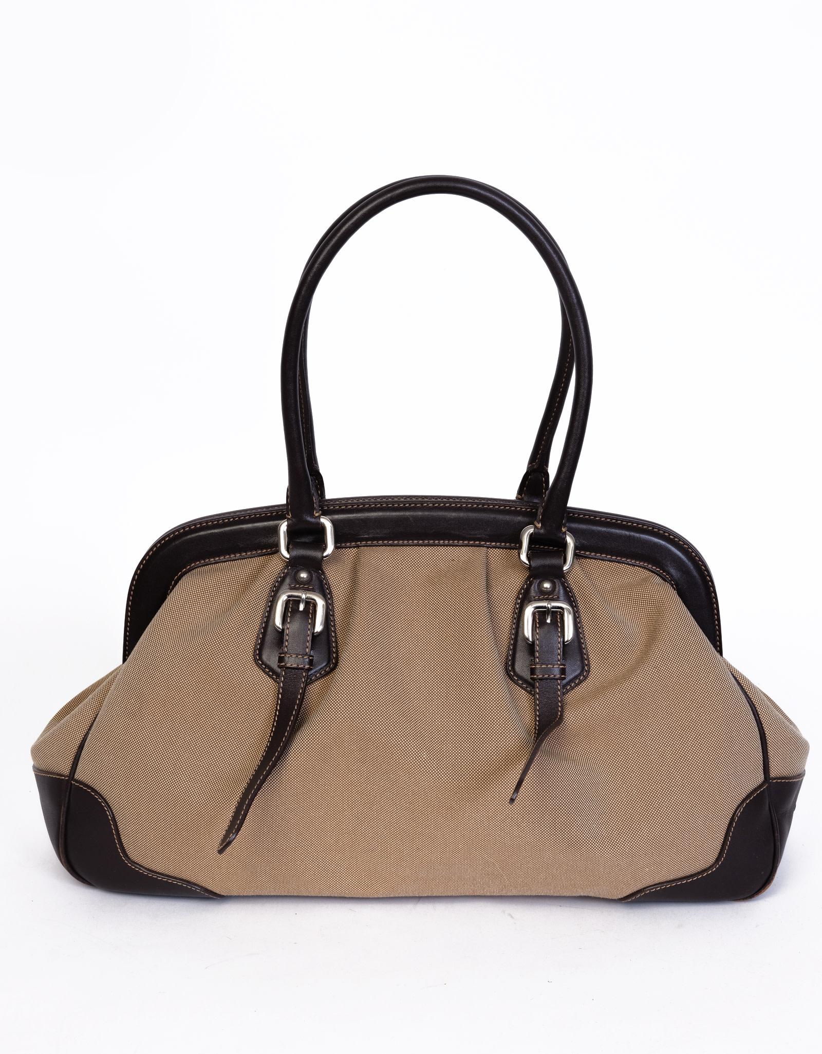 This bag is inspired by the traditional doctor bag style and is made with a durable camel canvas. Featuring logo embroidery at the front, dark brown cowhide leather finishes, dual flat top handles that attach to the bag via sliver tone links, top