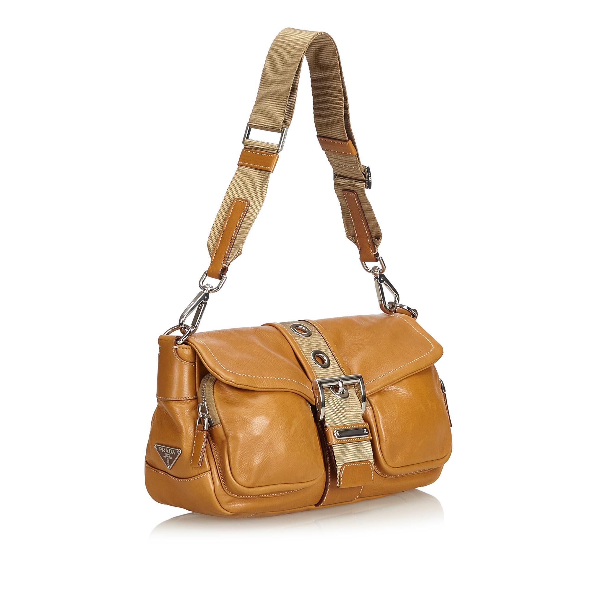 This shoulder bag features a leather body, a flat strap, a top flap with a belt detail, a top zip closure, and an interior zip pocket. It carries as B condition rating.

Inclusions: 
Dust Bag
Authenticity Card

Dimensions:
Length: 19.00 cm
Width: