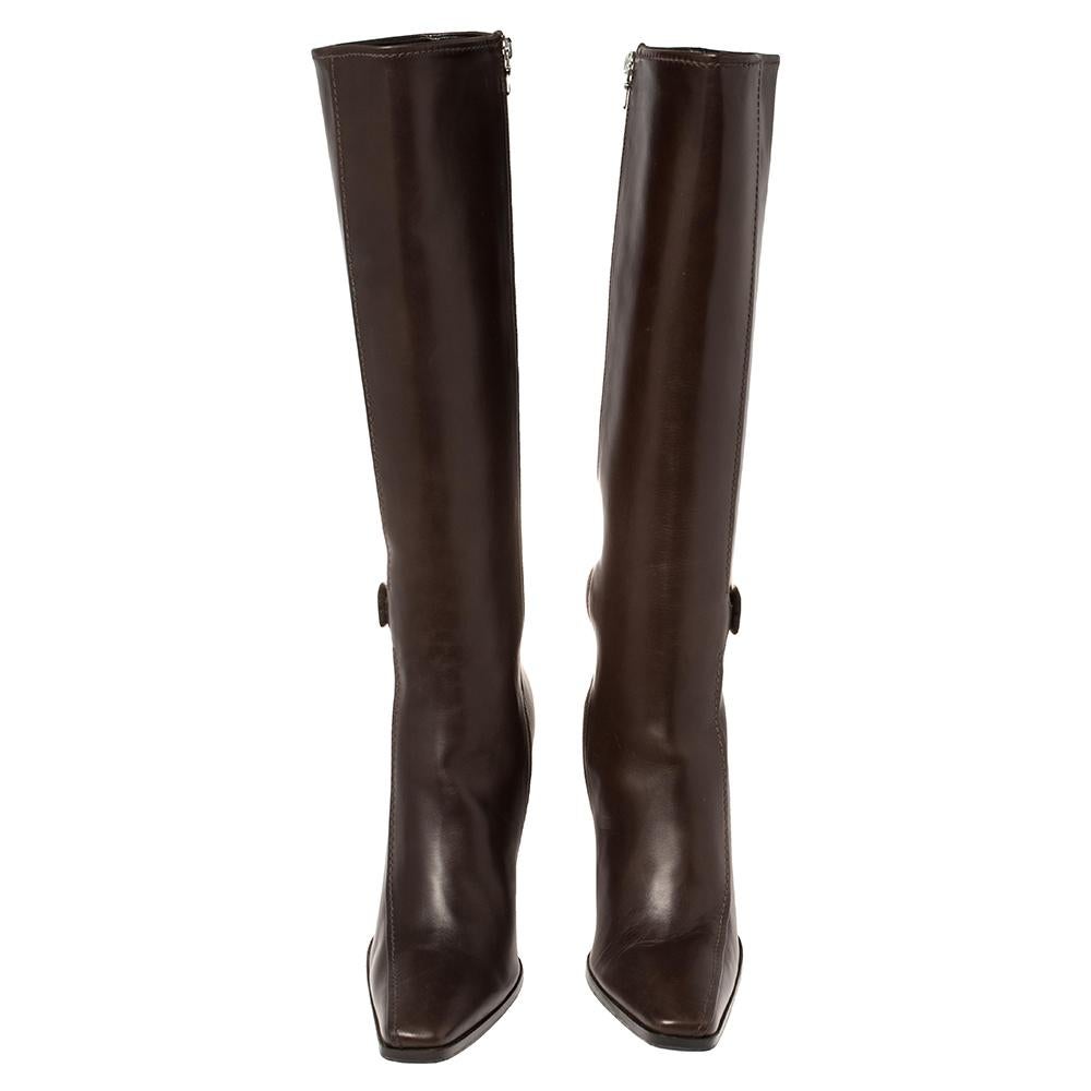 It's time to rock all your outings with these chic and smart knee-length boots from Prada. Exuding oodles of style, these brown leather boots are designed with square toes, silver-tone buckle details, and side zippers. They are endowed with