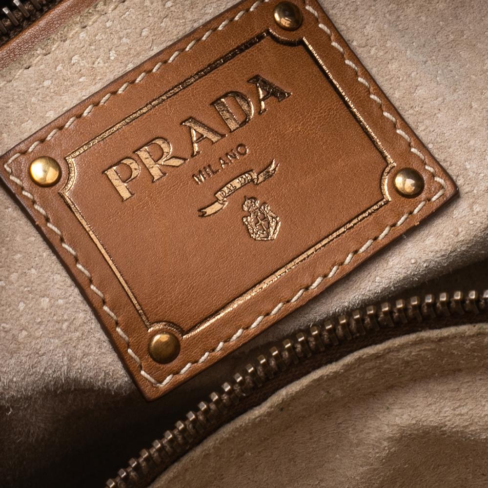 Prada delivers a sophisticated and chic tote crafted from leather. This tote is spaciously lined with suede that can hold your belongings for your daily commute or travel escapades. The bag suspends from dual leather handles.

