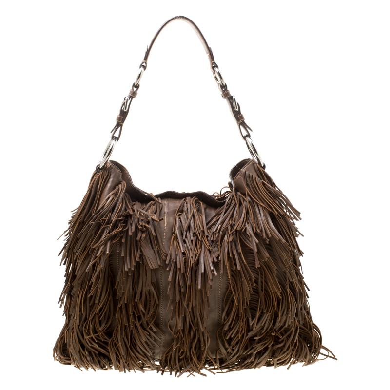 This hobo from Prada is crafted from brown leather and held by a single handle. Brimming with artistry and quality craftsmanship, the bag has an interior that is spacious enough to hold all your essentials. This bag, covered with fringes, is such a