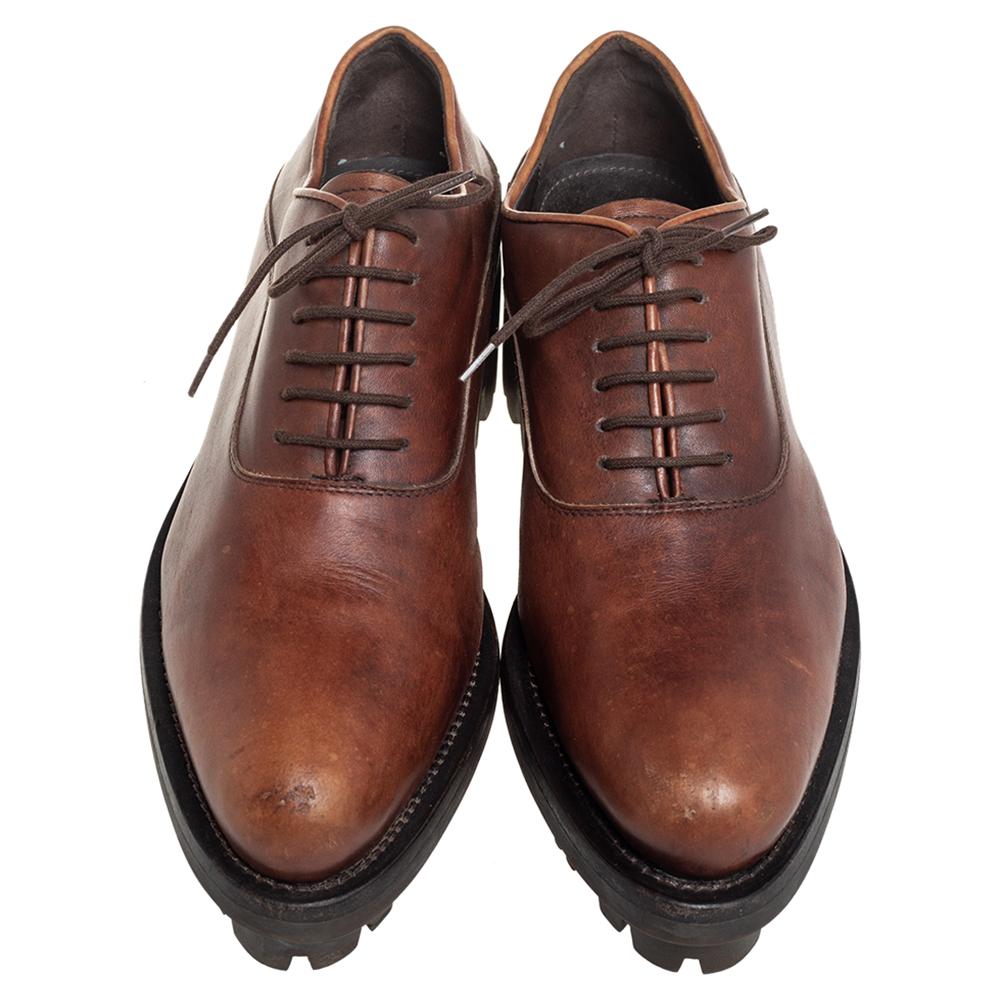 A luxurious blend of sports and class, these Prada oxfords have a unique design. They are made from leather in a brown shade and elevated by the chunky lug soles, laces, on the vamps, and round toes.

