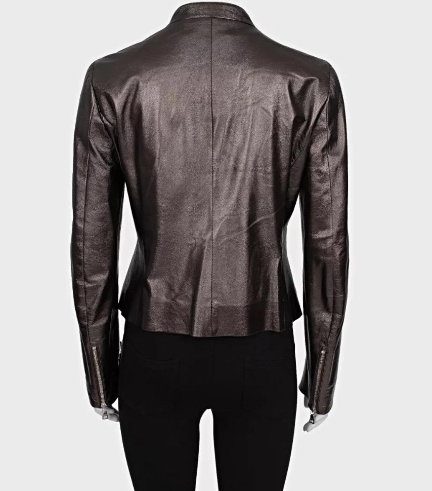 Eleva il tuo guardaroba con questa splendida giacca di pelle marrone di Prada! Realizzata al 100% in vera pelle, questa giacca emana raffinatezza e modernità. Il ricco colore marrone e la silhouette dritta lo rendono un pezzo versatile per ogni
