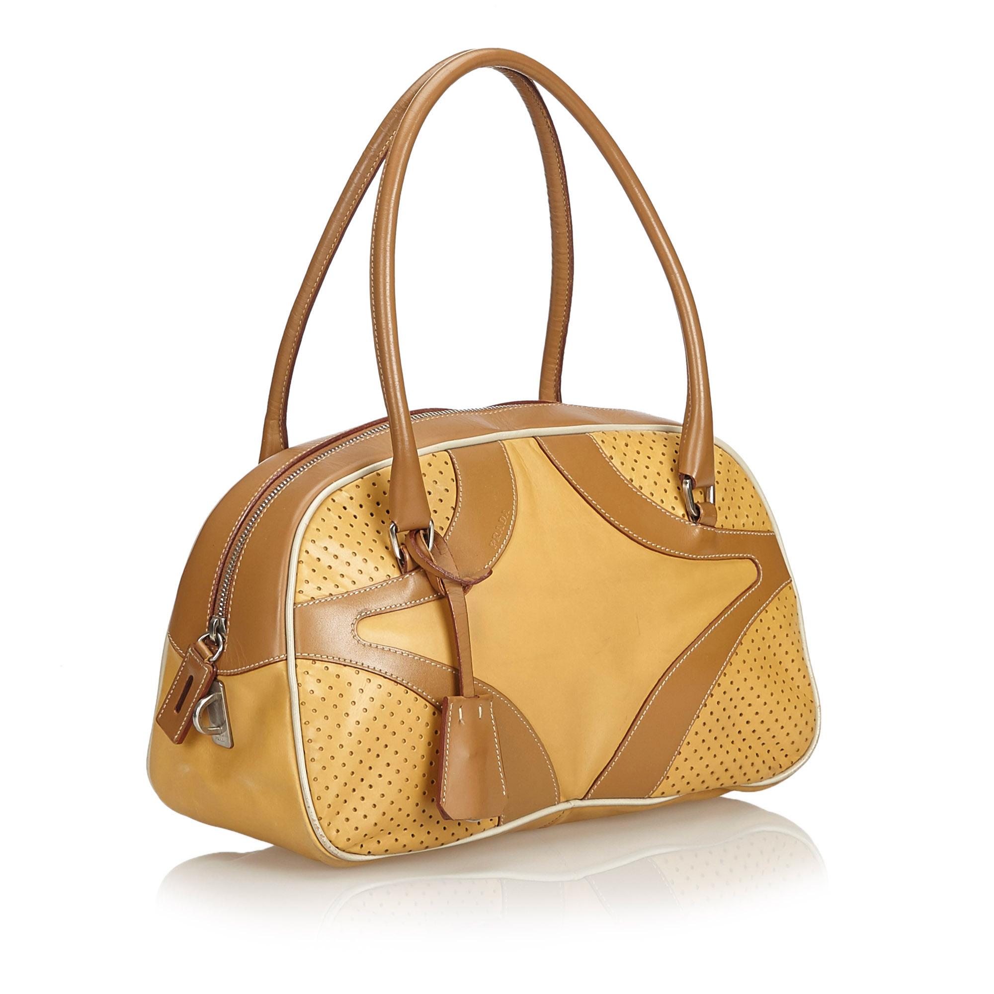This handbag features a perforated leather body, rolled handles, a top zip closure, and an interior zip pocket. It carries as B condition rating.

Inclusions: 
Dust Bag

Dimensions:
Length: 18.00 cm
Width: 33.00 cm
Depth: 11.00 cm
Hand Drop: 16.00