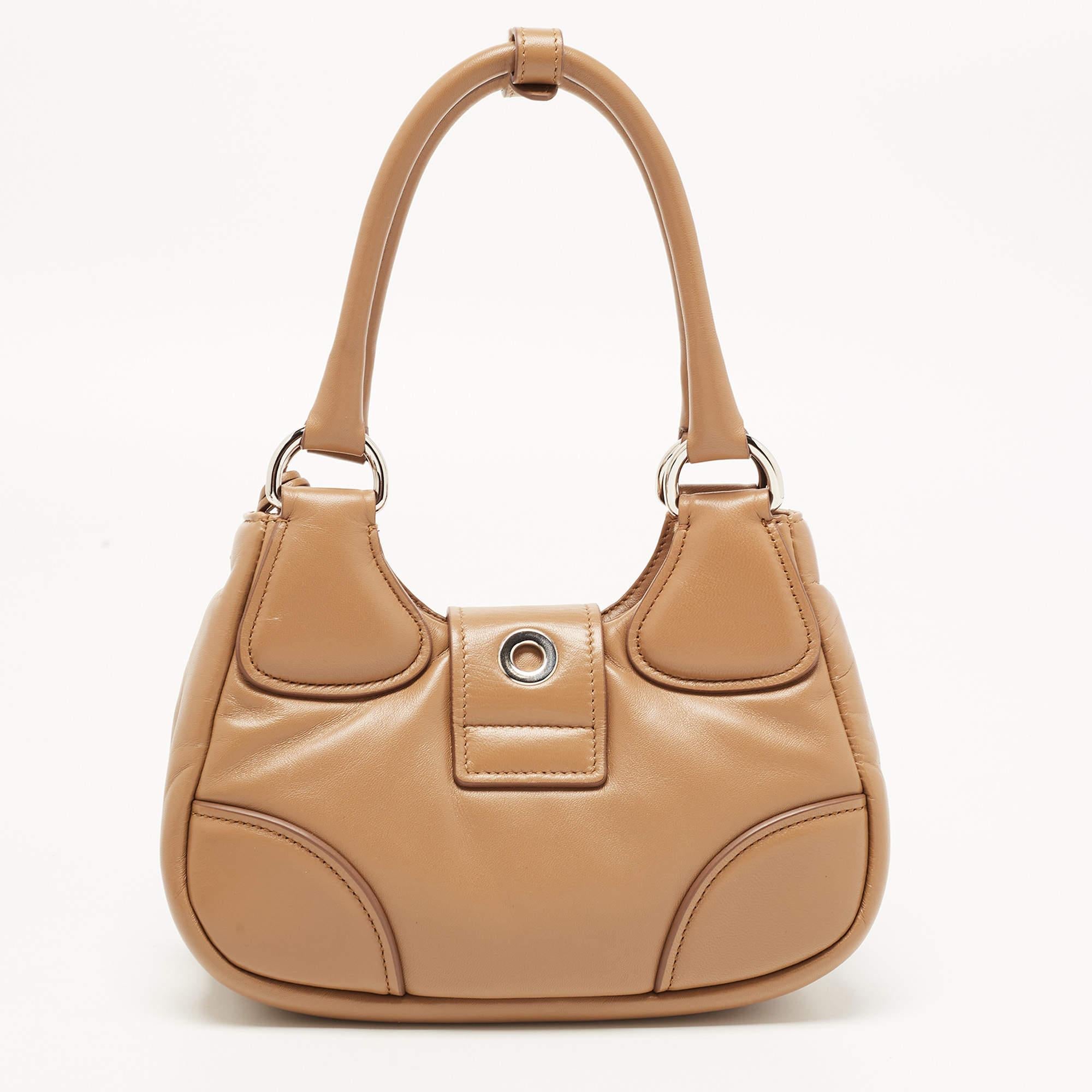 The Prada Re-edition 2002 bag is a luxurious accessory that exudes elegance and sophistication. Crafted from high-quality leather, it features a padded design and a rich brown color, showcasing a timeless aesthetic. With its re-edition status, this