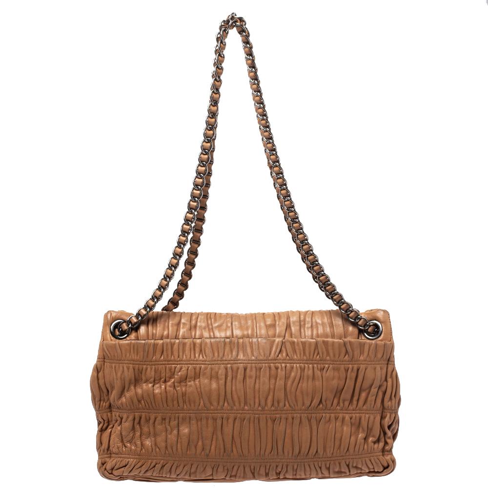 Have all eyes on you as you carry this chic flap bag from the house of Prada. Crafted from brown Nappa Guafre leather body, this bag comes fitted with chain-link shoulder straps and a flap style secured with a buckle closure with the brand logo. It