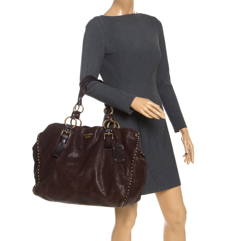 This stunning tote by Prada is a must-have. Crafted from durable Nappa leather, it comes in a lovely shade of brown. It features gold-tone hardware, studded accents at exterior, logo at the front, dual shoulder straps featuring O-ring accents,