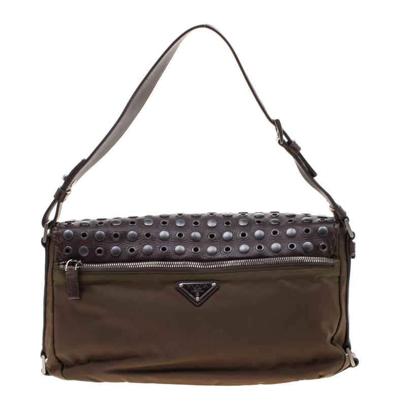 Enhance your look with this bag crafted from nylon. It features a leather flap which is adorned with studs and eyelets for an edgy appeal. Get yourself this alluring piece for an uptown look. The spacious interior is lined with monogrammed nylon and