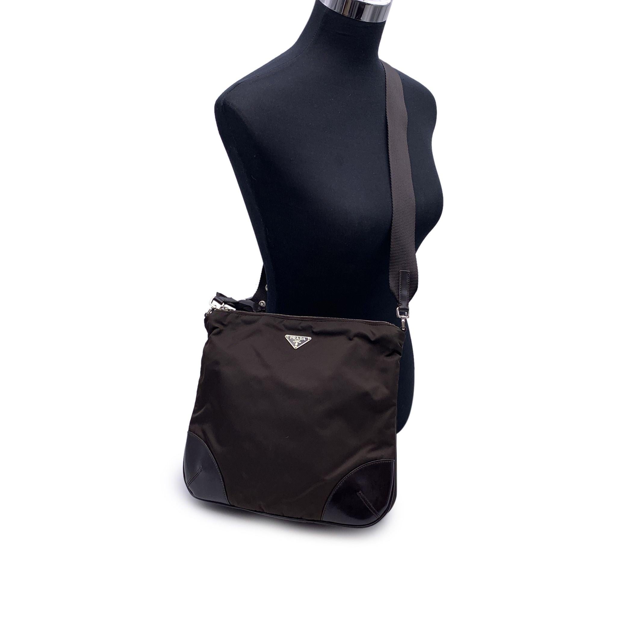 Vintage PRADA Messenger Bag . Silver metal hardware. Crafted in brown tessuto nylon canvas withn brown leather trim. Prada triangle logo on the front. Upper zipper closure. Brown signature canvas lining. Adjustable shoulder strap. 'Prada - Made in